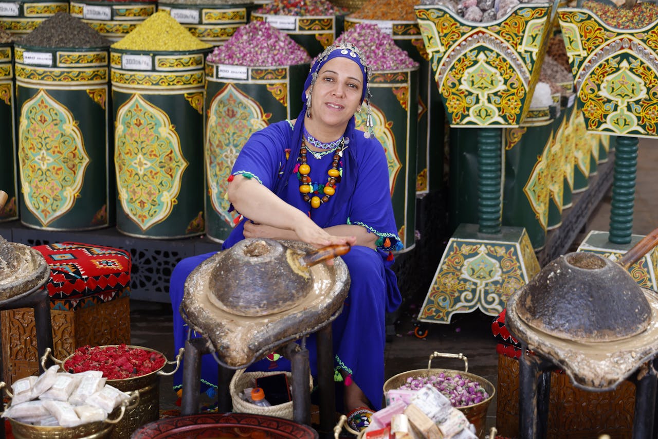 A Moroccan woman selling spices in a traditional bazaar, showcasing vibrant culture and colors.