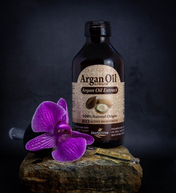 High-quality product shot of argan oil with purple flower for beauty and skincare applications.